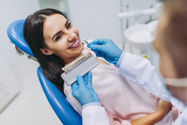 אישה מחייכת אחרי טיפול לציפוי שיניים באמצעות ציפויי למינייט